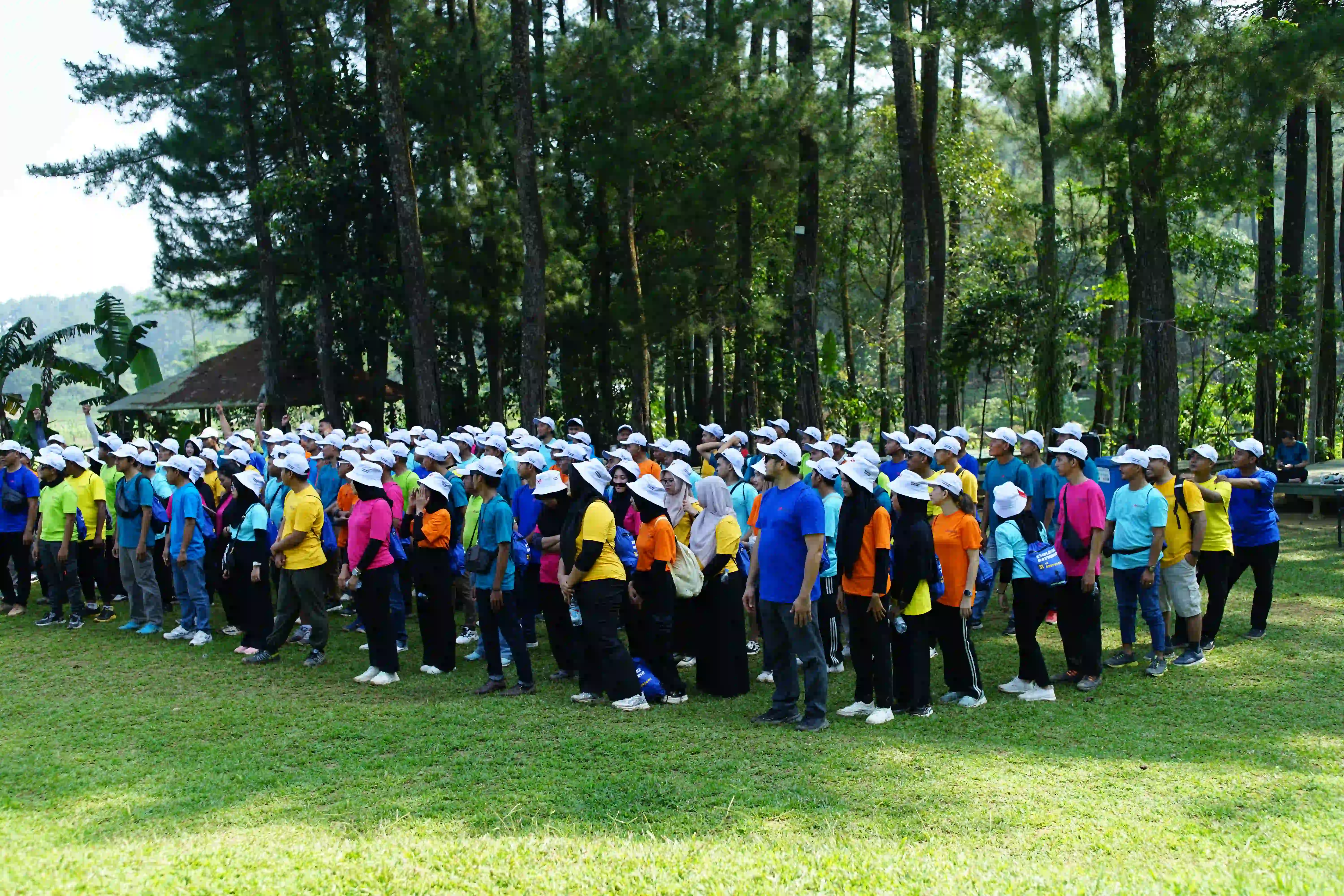 Tim bonding di depan air terjun dengan suasana ceria dan produktif.