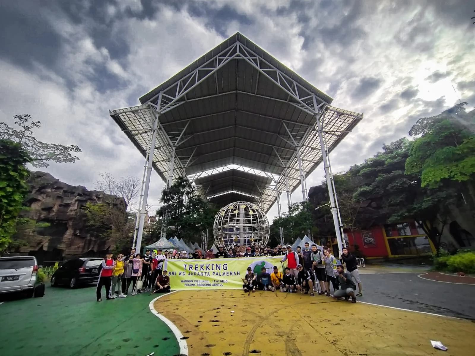 Suasana seru team bonding di area air terjun dengan peserta yang saling mendukung.