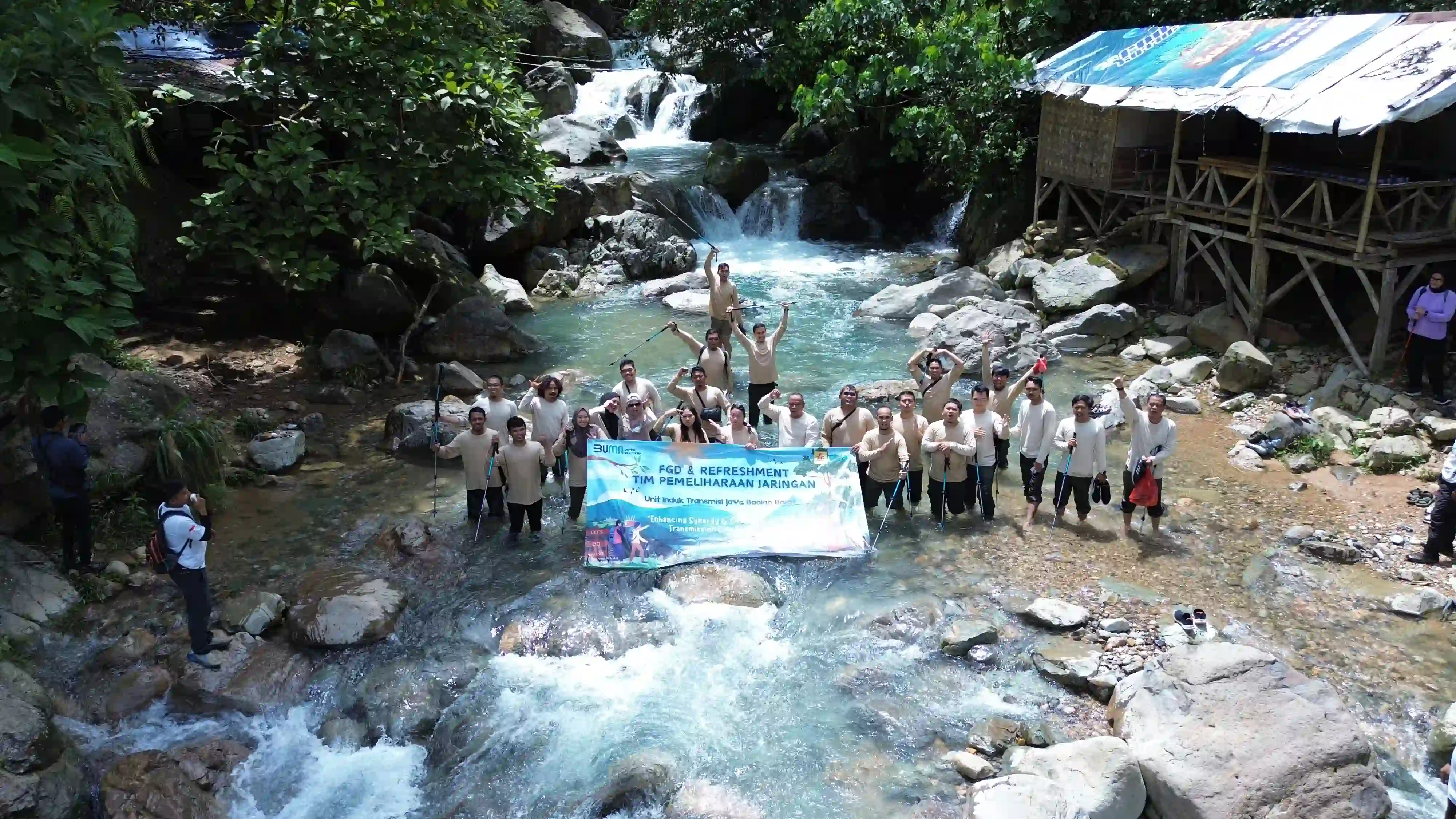 Tim perusahaan berfoto bersama di tengah perjalanan trekking yang menyenangkan.